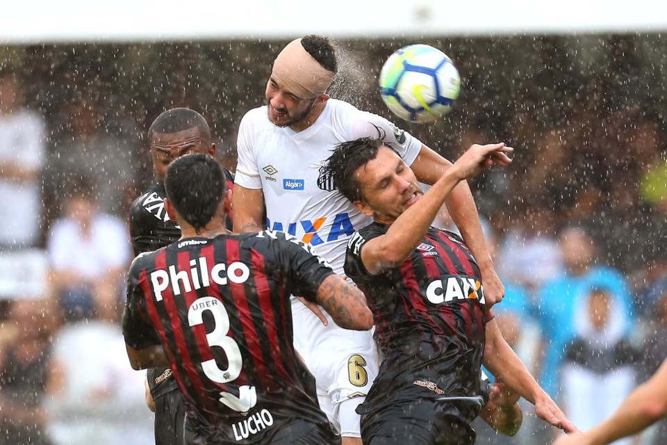 Sob muita chuva, atletas de Santos e Atlético-PR disputam bola na Vila Belmiro | Guilherme Dionizio/Estadão Conteúdo