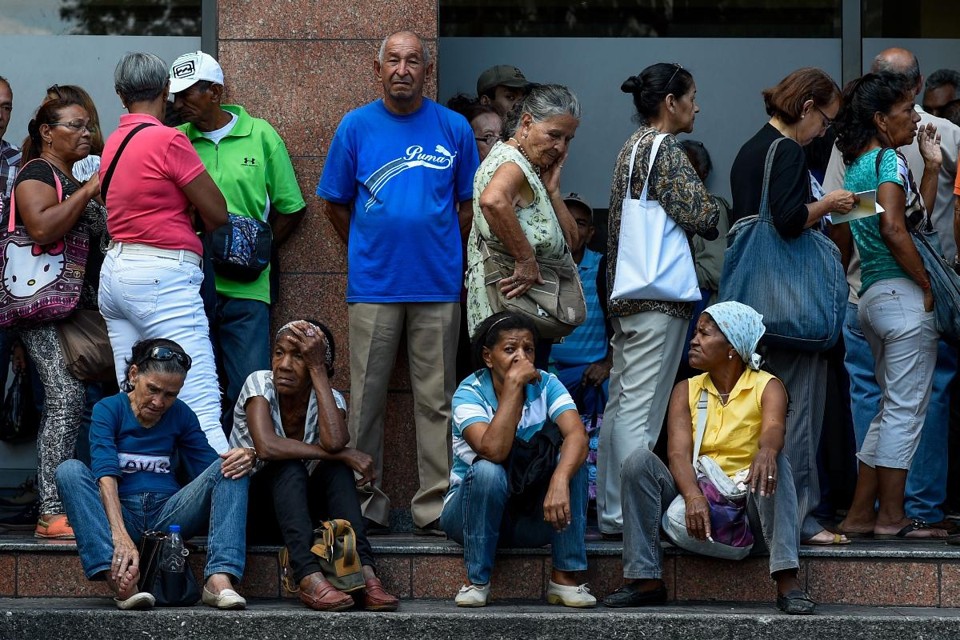 Pessoas aguardam em fila para poder retirar dinheiro em agência bancária em Caracas | FEDERICO PARRA/AFP