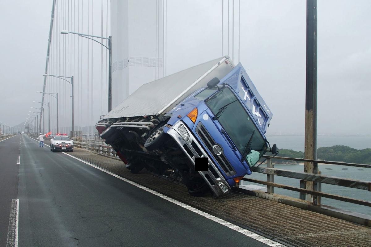 Caminhão tomba depois de ser arrastado por fortes ventos causados pelo tufão Jebi na ponte Seto Ohashi, em Sakade | JIJI PRESS/AFP