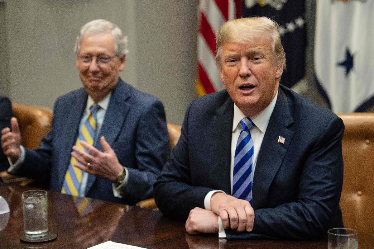 O líder da maioria no Senado dos EUA, o republicano Mitch McConnell (E) reage enquanto o presidente Donald Trump fala à imprensa antes de uma reunião com os líderes congressistas republicanos na Casa Branca, em 5 de setembro de 2018 | NICHOLAS KAMM/AFP