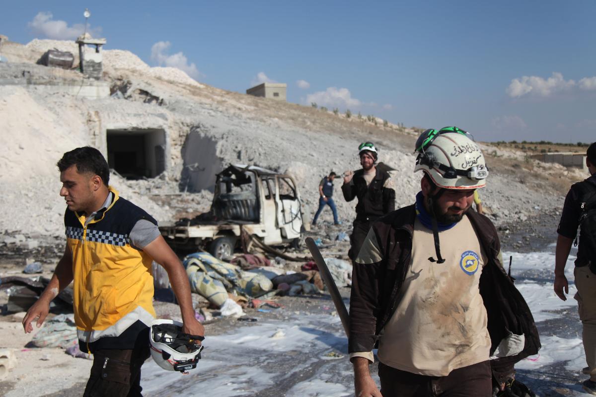Membros da defesa civil síria vasculham local na cidade de Hass depois de um ataque aéreo por forças pró-regime no sul da província de Idlib, em 8 de setembro de 2018 | AMER ALHAMWE/AFP
