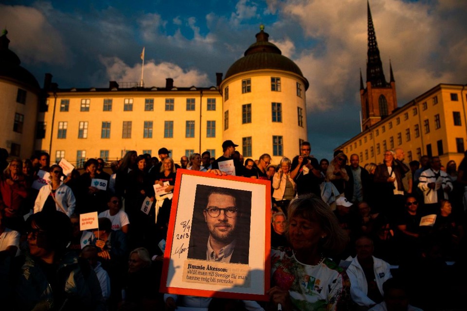 Apoiadores do Partido dos Democratas Suecos ergue um cartaz com a foto do líder do partido, Jimmie Akesson, antes de um evento de campanha em Estocolmo, Suécia, em 8 de setembro de 2018 | JONATHAN NACKSTRAND/AFP