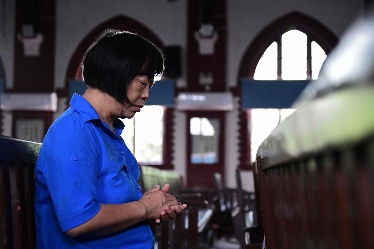 Mulher reza dentro da igreja Christian Glory, em Wuhan, na China. Acordo histórico entre a China e o Vaticano é uma vitória para Pequim | NICOLAS ASFOURI/AFP