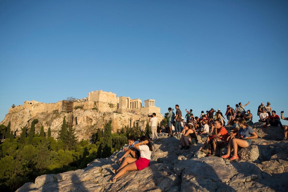 Turistas perto do Partenon, um dos cartões postais da Grécia | EIRINI VOURLOUMIS/NYT