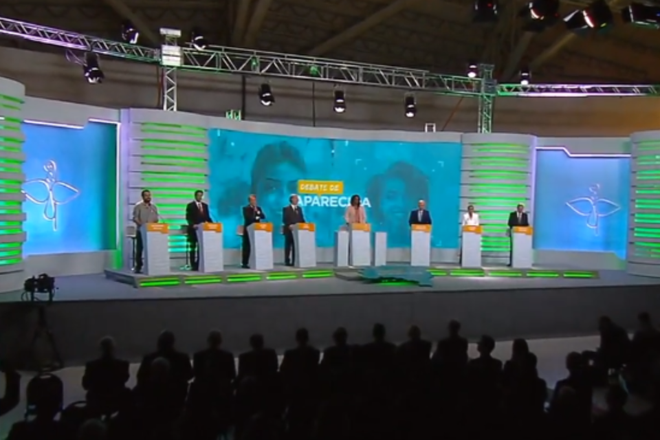 No debate da TV Aparecida, Haddad estreia mal e CNBB se omite O chargista Paixão está de férias | TV Aparecida / Reprodução YouTube
