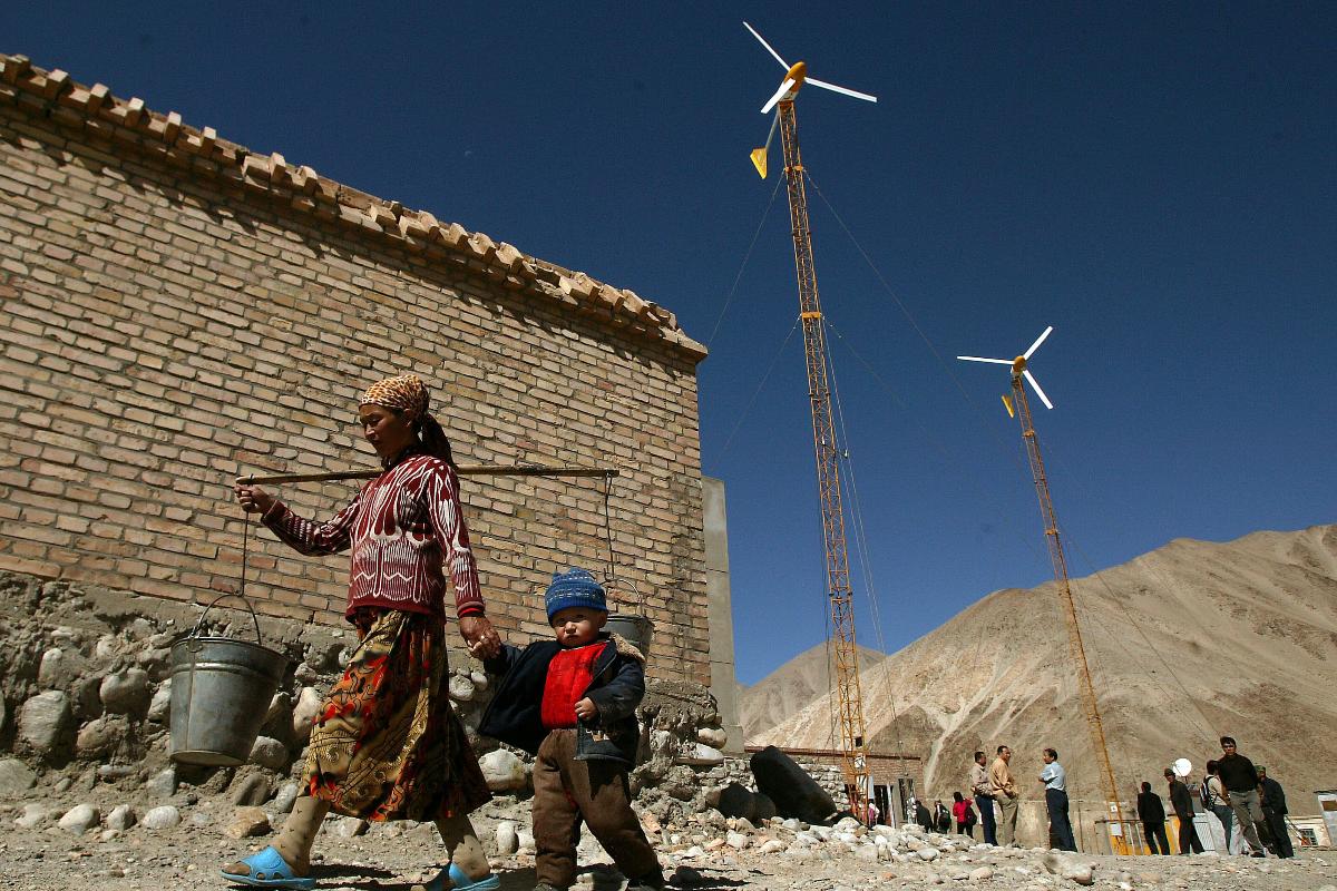 Uma mulher Uighur com seu filho busca água no distrito remoto de Bulunkou, nas montanhas ao sul de Kashgar, Xinjiang | Stephen Shaver/Bloomberg