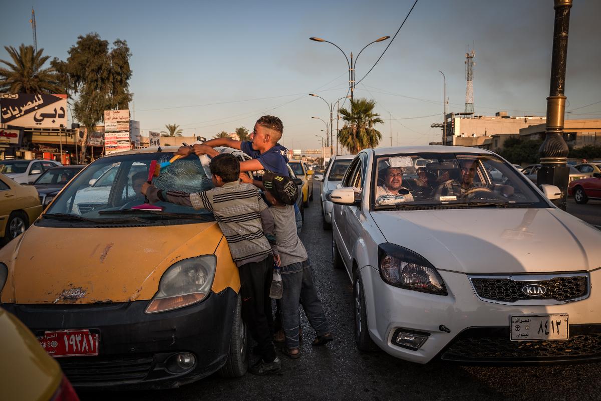 Said Dadoush, cujo pai foi morto na guerra, limpa parabrisa de carro em Mossul | ANDREA DICENZO/
NYT