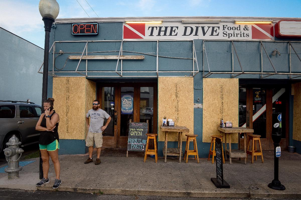 Placas de madeira compensada protegem as janelas de um restaurante, frente à chegada do furacão Florence, em Carolina Beach, Carolina do Norte, em 11 de setembro de 2018 | Charles Mostoller/Bloomberg