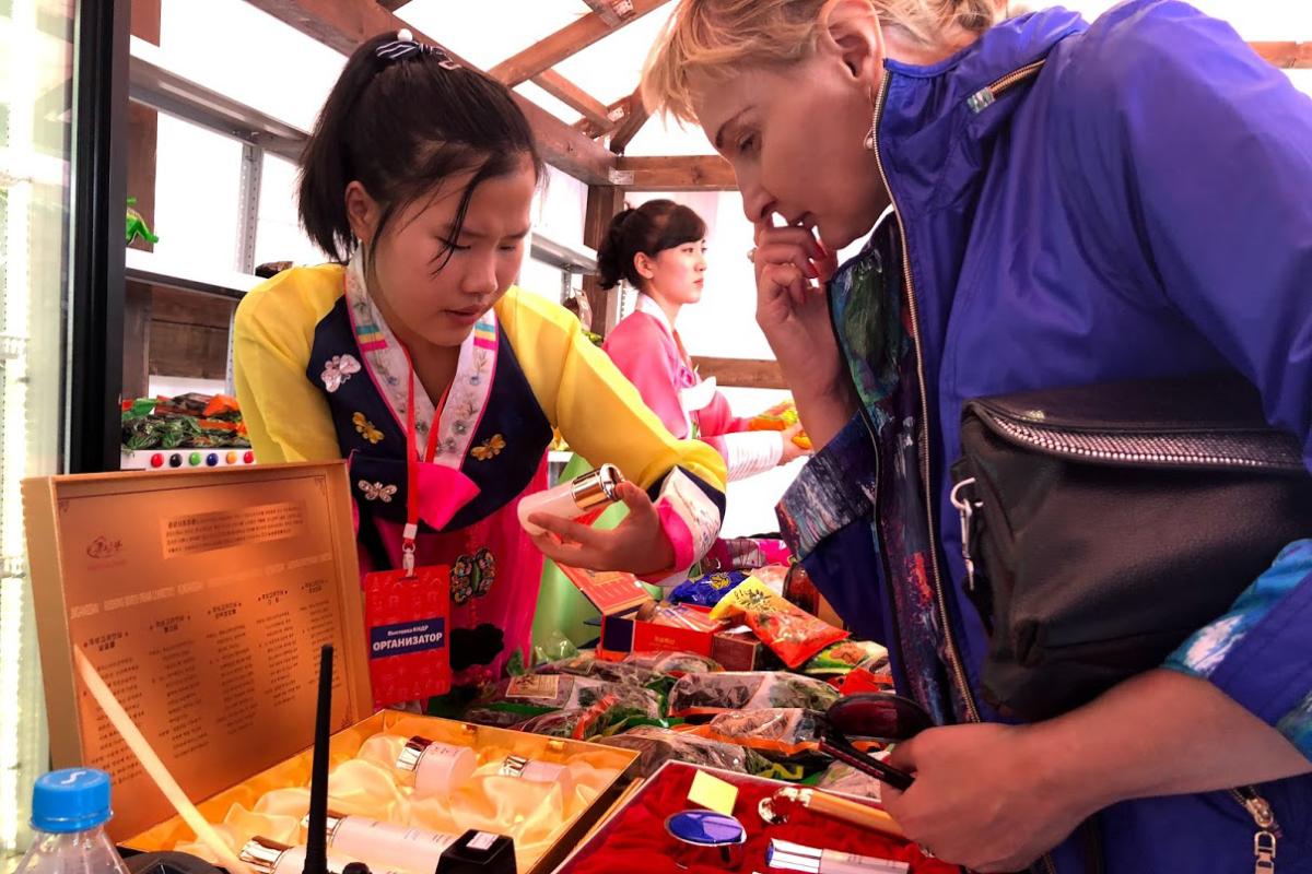 Trabalhadores norte-coreanos vendem as mercadorias de seu país em uma feira em Vladivostok, Rússia, celebrando o 70º aniversário da fundação da Coreia do Norte | Anton Troianovski/
The Washington Post