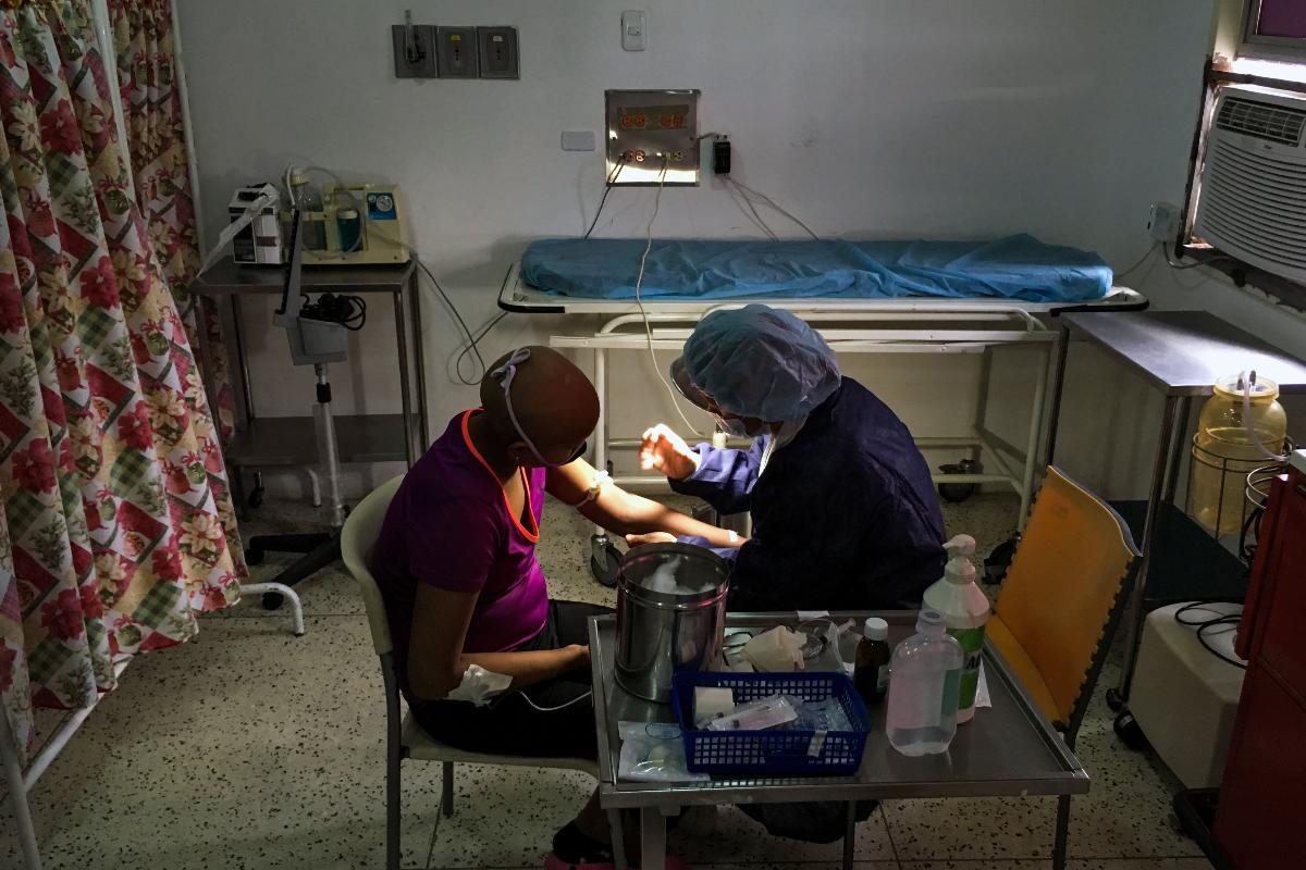 Uma menina é assistida por uma enfermeira na sala de quimioterapia do Hospital Infantil Dr. JM de los Rios, em Caracas | FEDERICO PARRA/AFP