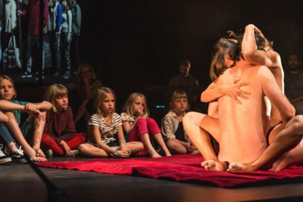 Crianças assistem a simulação erótica durante a performance Lam Gods, em Gent, na Bélgica