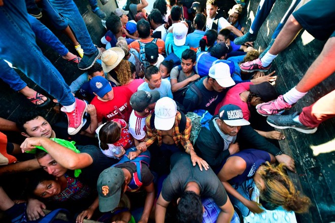Migrantes hondurenhos a bordo de um caminhão em Metapa, a caminho de Tapachula, no México, em 22 de outubro de 2018. Grupo seguirá para os EUA | PEDRO PARDO/AFP