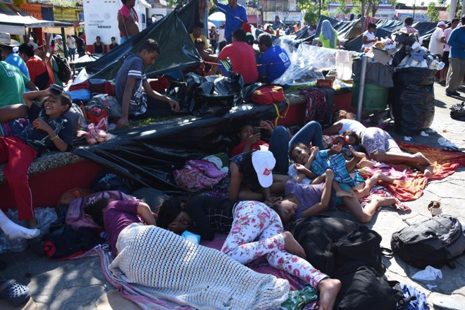 Migrantes hondurenhos que participam de caravana que vai aos EUA descansam durante a jornada | JOHAN ORDONEZ/AFP