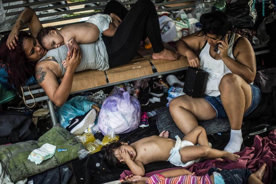 Migrantes hondurenhos que participam de uma caravana em direção aos EUA descansam em um acampamento improvisado durante uma parada em Huixtla,  no México, em 23 de outubro  | PEDRO PARDO/AFP