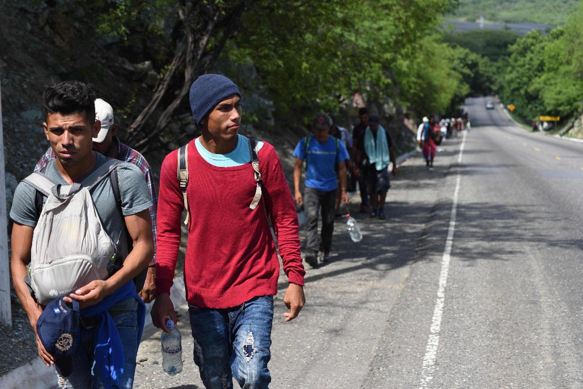 Migrantes em nova caravana rumo aos Estados Unidos caminham ao largo de rodovia na Guatemala | ORLANDO ESTRADA/AFP