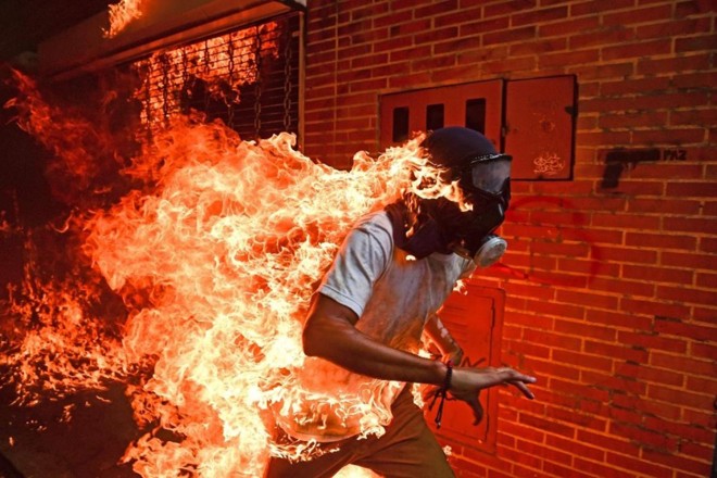 José Victor Salazar Balza (28) em chamas durante confrontos violentos entre manifestantes e as forças de segurança da Venezuela, em maio de 2017, depois que o governo Nicolás Maduro convocou uma Assembleia Nacional Constituinte. | Ronaldo Schemidt/
AFP