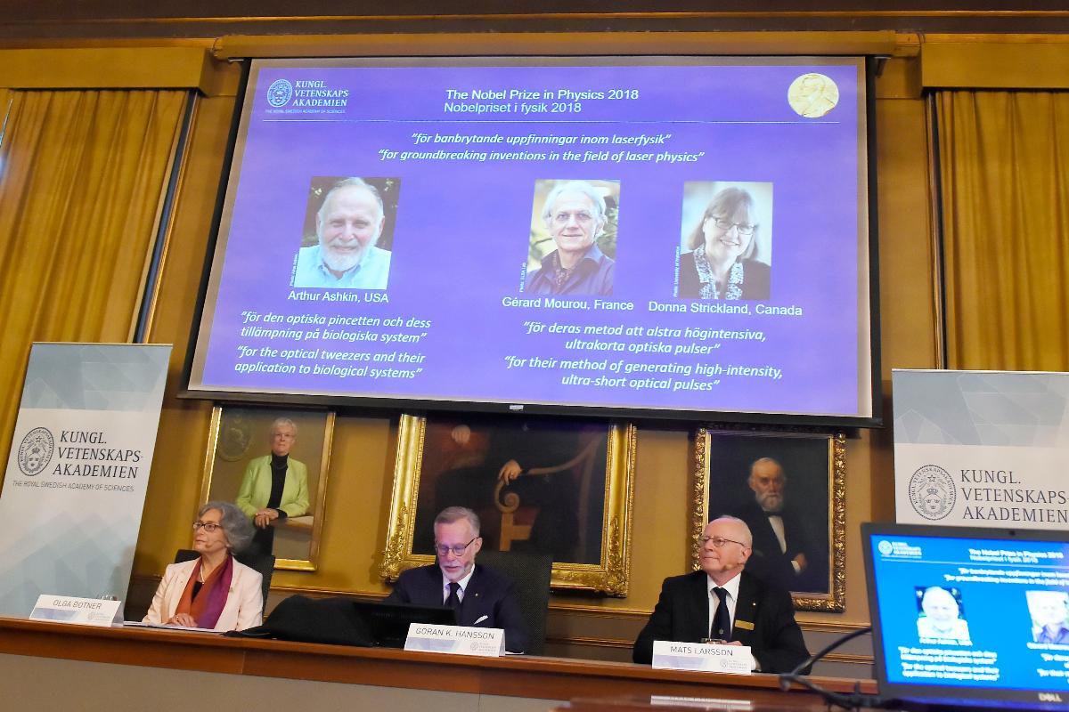 Membros do Comitê Nobel de Física, Olga Botner, Goran K Hansson e Mats Larsson apresentam os vencedores do Nobel de Física na tela: Arthur Ashkin dos Estados Unidos, Gerard Mourou da França e Donna Strickland do Canadá | HANNA FRANZEN/AFP
