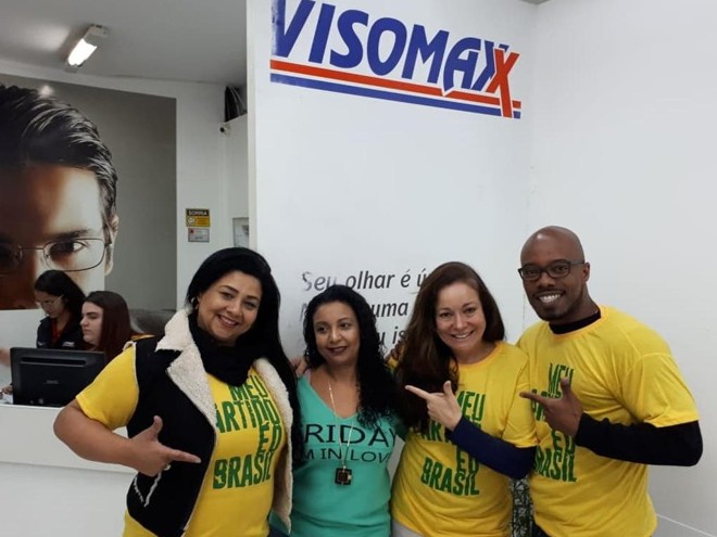 Adriana Dias, dona da rede Visomax, ao centro, junto com uma funcionária que preferiu não usar a camiseta encomenda pela empresa. | Katia Brembatti/Gazeta do Povo