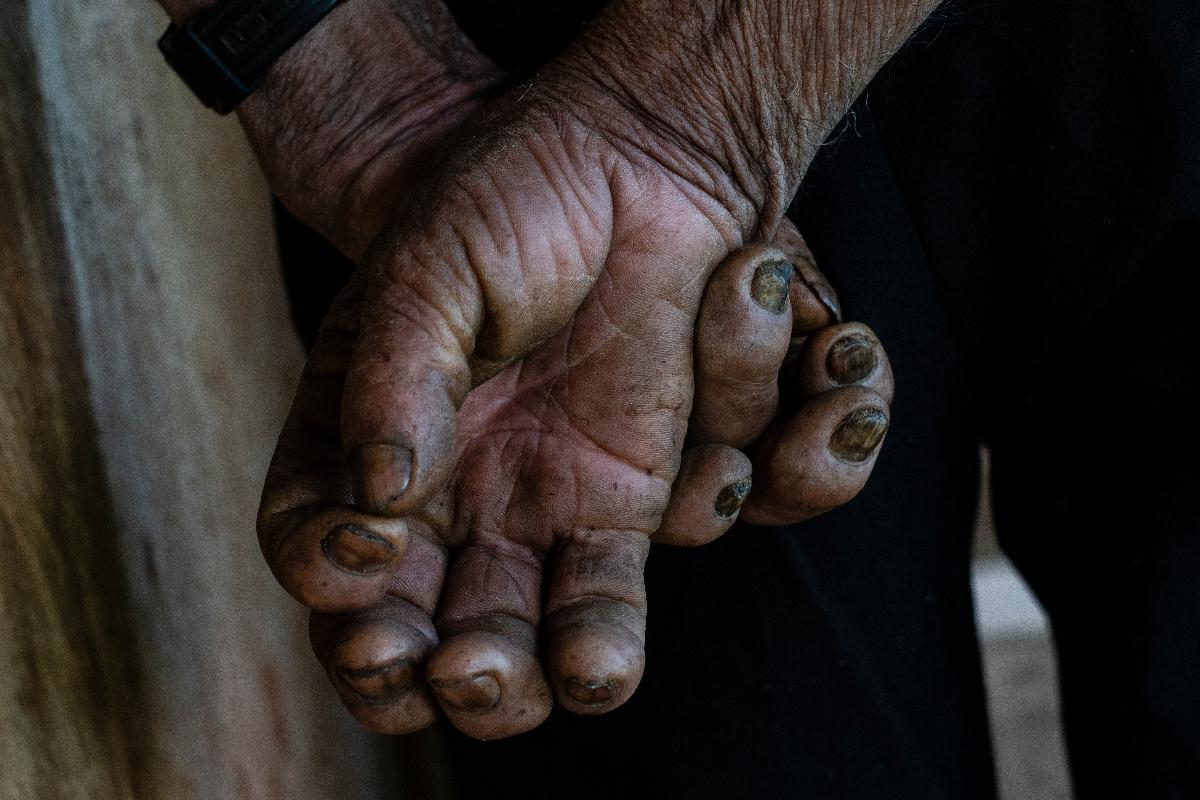 Mãos cruzadas de pequeno agricultor durante velório de líder comunitário no interior da Colômbia | FEDERICO RIOS ESCOBARNYT