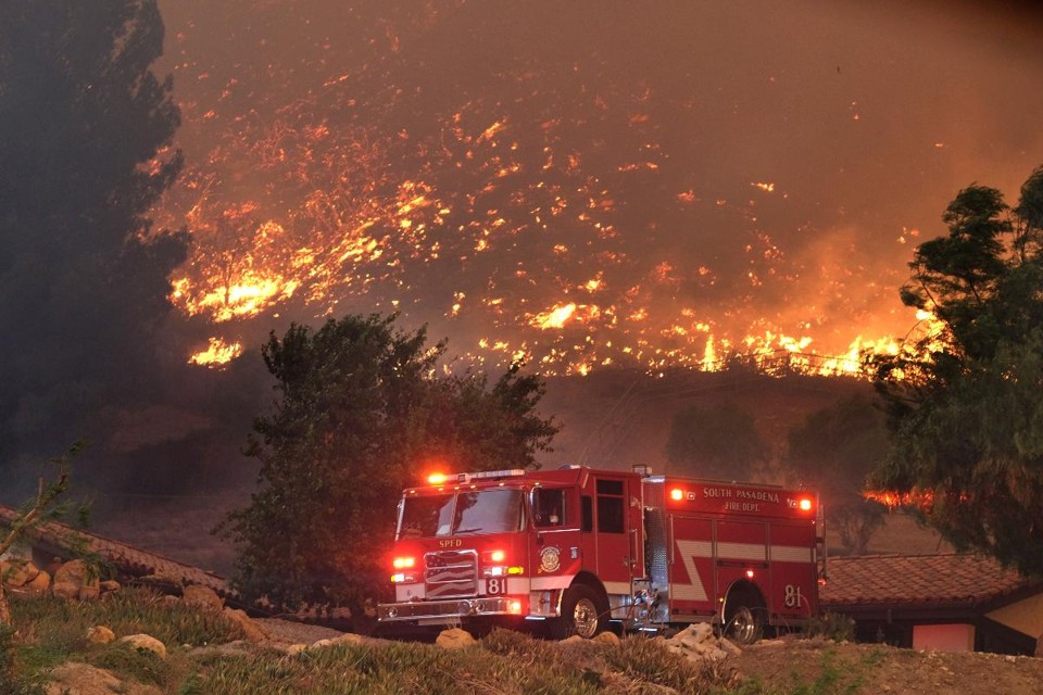 Bombeiros trabalham para proteger estruturas enquanto as chamas se espalham em Agoura Hills, California, 9 de novembro | Matthew Simmons / AFP