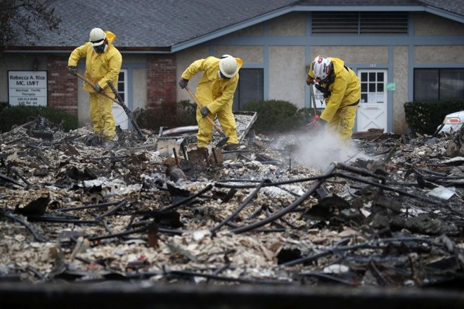 Equipe de resgate vasculha os escombros de um comércio queimado pelo Camp Fire em busca de restos humanos, em Paradise, 21 de novembro | JUSTIN SULLIVAN / AFP