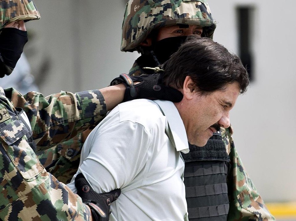 O narcotraficante Joaquin Guzman, "El Chapo", escoltado por fuzileiros navais na Cidade do México, em 22 de fevereiro de 2014, quando foi preso em um resort no norte do país | RONALDO SCHEMIDT / AFP