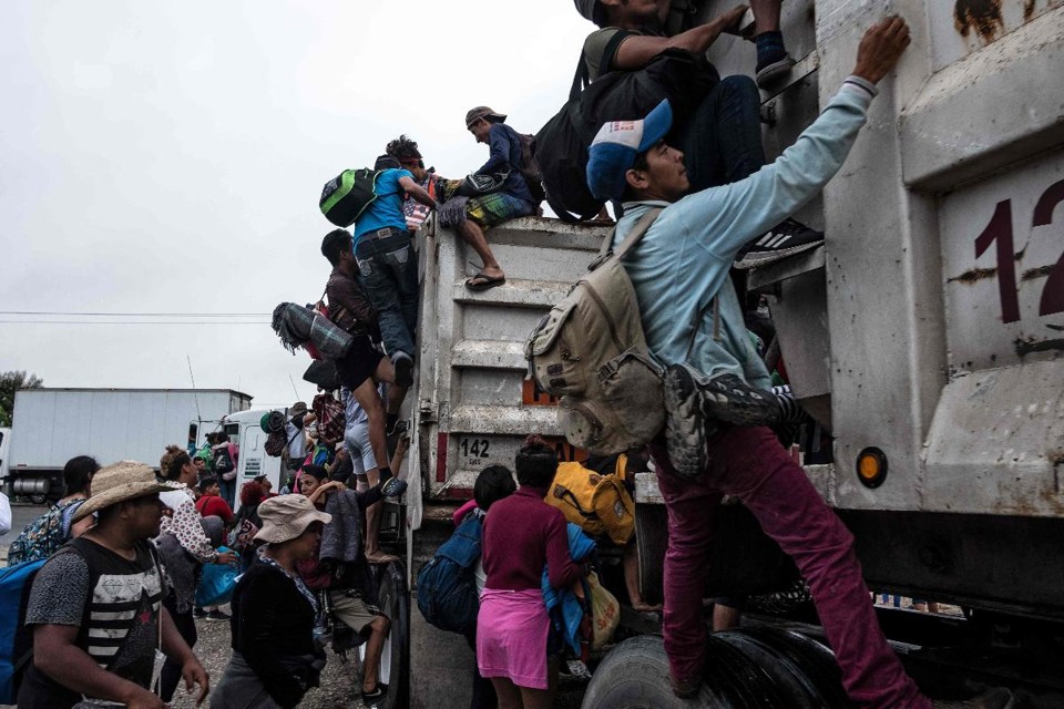 Maioria dos migrantes são hondurenhos. Em alguns pontos do trajeto, eles contam com a carona em caminhões. | GUILLERMO ARIASAFP