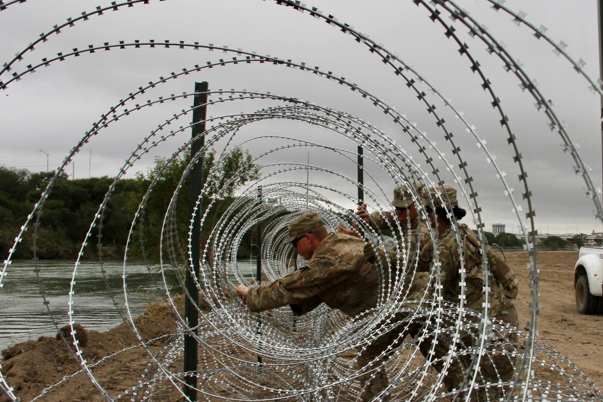 Soldados do 19º Batalhão de Engenheiros do Kentucky instalam cercas de arame farpado nas margens do Rio Grande, em Laredo, em 18 de novembro, às vésperas da chegada da caravana de imigrantes centro-americanos | THOMAS WATKINS/AFP