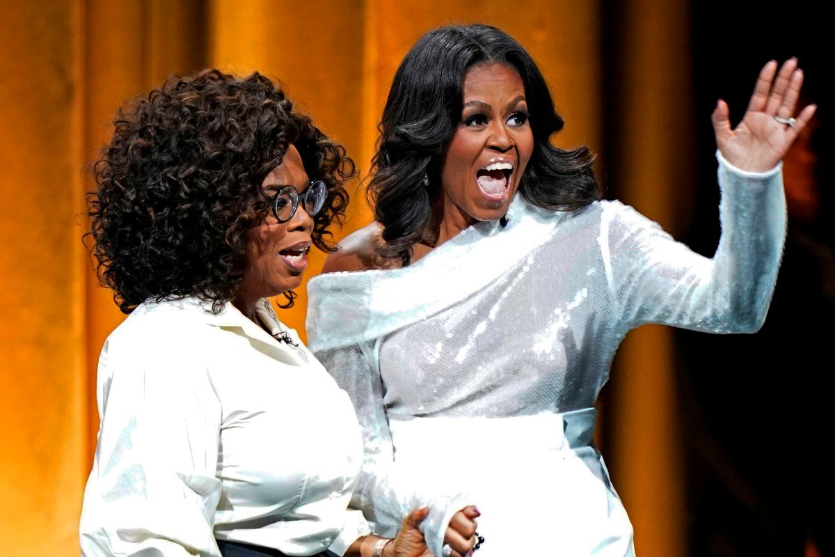 A ex-primeira dama americana Michelle Obama e a apresentadora Oprah Winfrey na estreia da turnê mundial de Michelle para lançamento de livro, em 13 de novembro | JIM YOUNG /
AFP
