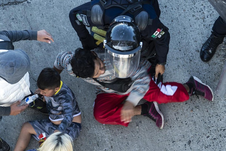 Migrantes da América Central são parados pelas forças policiais mexicanas ao chegarem à fronteira em Tijuana, Estado de Baja California, México, em 25 de novembro de 2018 | PEDRO PARDO/AFP