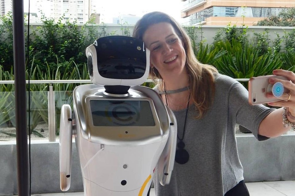Fernanda Schaper, gerente da unidade, tira uma selfie com a robô Rebeca. | Ramada Encore Hotel/Facebook
