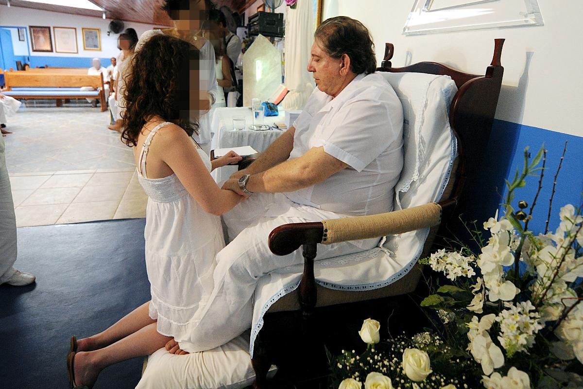 O médium brasileiro João de Deus trata paciente em sua Casa de Dom Inácio de Loyola, em Abadiania, 120 km a sudoeste de Brasília, estado de Goiás, em abril 4, 2012. Centenas de pessoas visitam a casa fundada em 1978 pelo curandeiro popular João Teixeira, mais conhecido como João de Deus, em busca de cura para doenças. | PEDRO LADEIRA/AFP