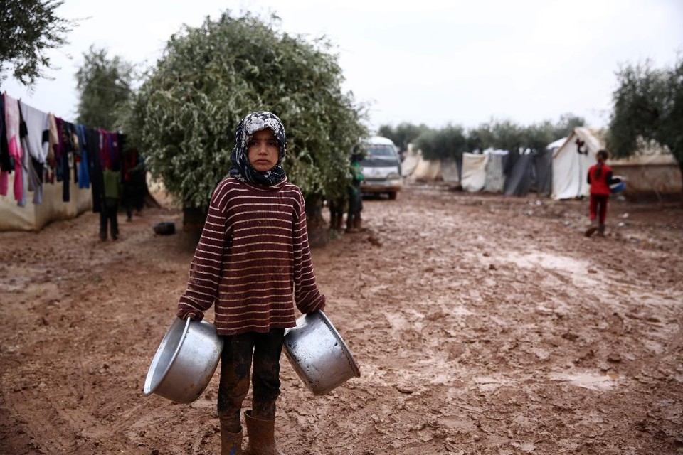 Menina síria em acampamento de desabrigados perto da vila de Shamarin, próximo à fronteira com a Turquia, em 6 de dezembro | NAZEER AL-KHATIB / AFP