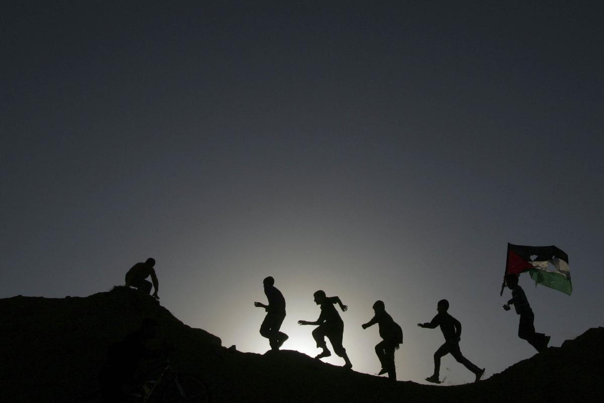 Meninos palestinos brincam ao Norte da Faixa de Gaza. | MOHAMMED SALEM