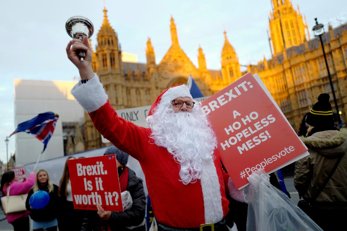 Em Londres, manifestante vestido de Papai Noel protesta contra o plano da primeira-ministra Theresa May e todo o embróglio causado pelo Brexit | TOLGA AKMEN/AFP