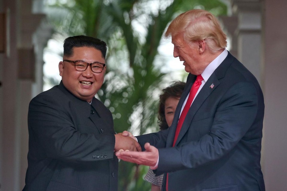 Ditador da Coreia do Norter, Kim Jong-un, cumprimenta o presidente dos EUA, Donald Trump | KEVIN LIM/AFP