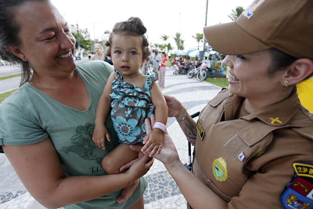 PM bota pulseirinha de identificação no braço de bebê: segurança para os pais na praia. | Albari Rosa/Gazeta do Povo