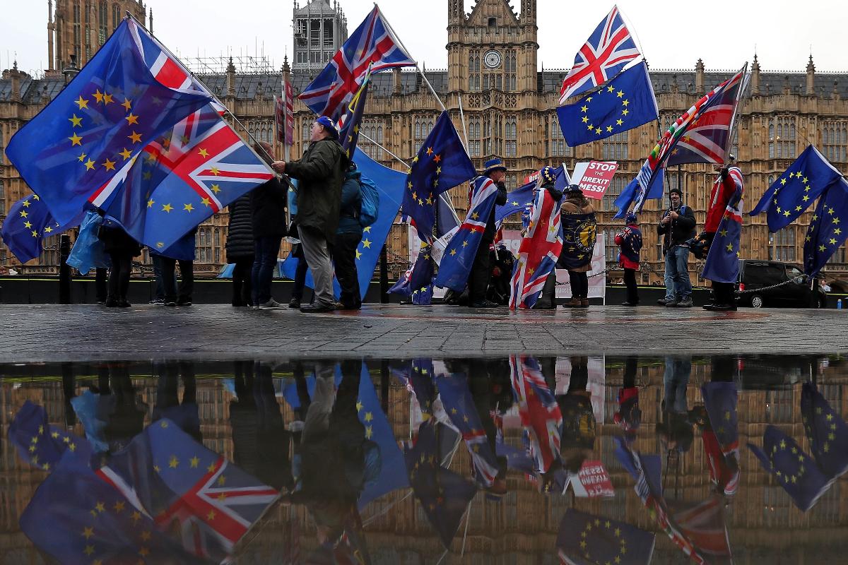 Pró-União Europeia (UE), manifestantes anti-Brexit acenam bandeiras da UE e do Reino Unido enquanto protestam em frente às Casas do Parlamento, em Londres | DANIEL LEAL-OLIVAS/AFP