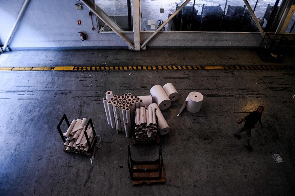 Funcionário caminha ao lado dos rolos de papel restantes na sala de impressão do jornal venezuelano El Nacional, em Caracas, em 6 de Outubro | FEDERICO PARRA/AFP