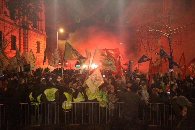 Manifestação de membros e simpatizantes de vários sindicatos, partidos políticos e organizações civis em frente ao prédio do parlamento em protesto contra mudanças no código de trabalho, em Budapeste em 16 de dezembro | PETER KOHALMI/AFP