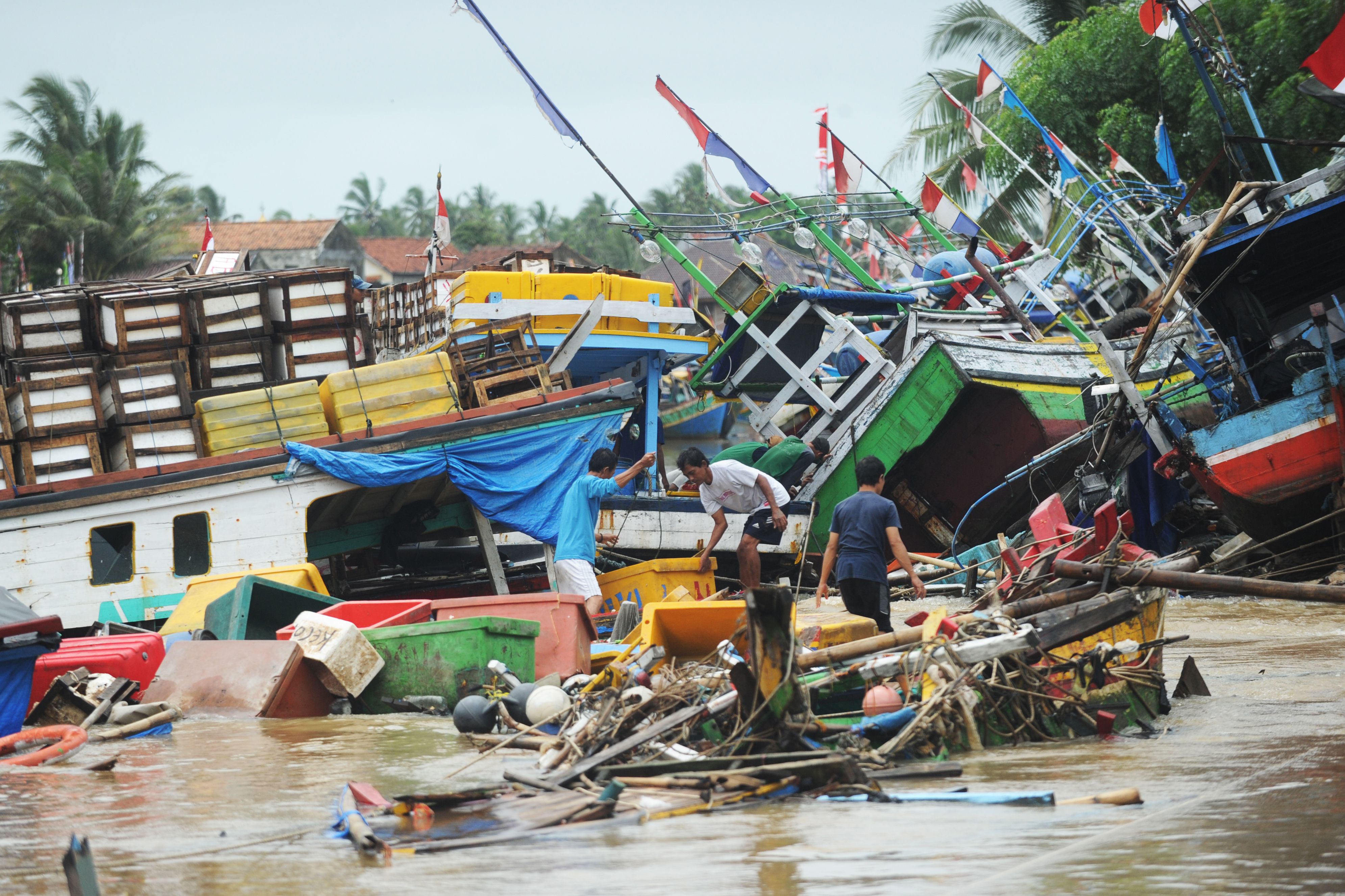 Pescadores tentam reaver seus barcos em meio a escombros após Tsunami | SONNY TUMBELAKA/AFP