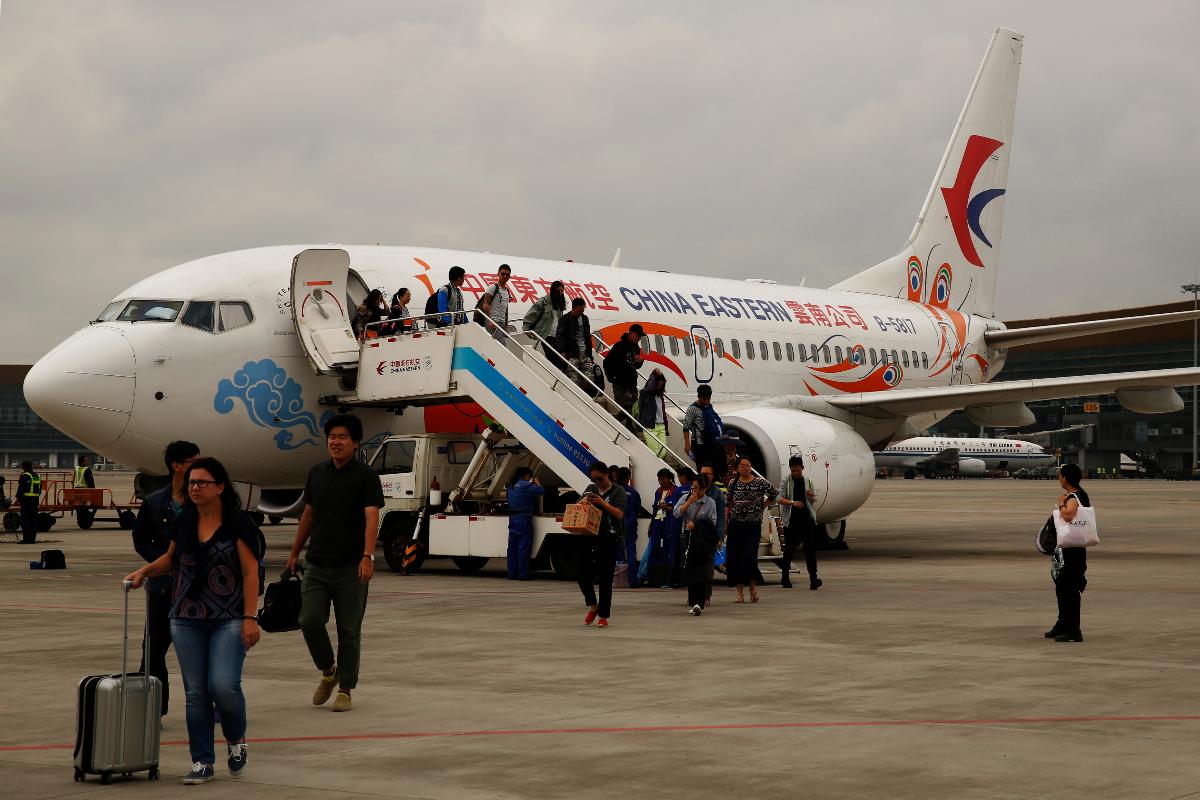 Passageiros desembarcam de um Boeing 737 no aeroporto de Kunming, na China | Luke MacGregor/Bloomberg