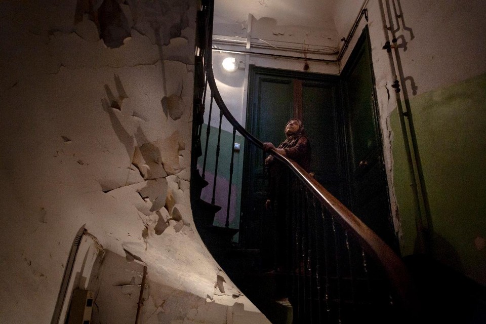 Moradora na escadaria de um prédio no centro de Marselha, onde um relatório de 2015 mostrou que 40 mil moradias eram inseguras | ANDREA MANTOVANI / NYT