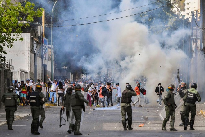 Polícia de Choque entra em confronto com manifestantes contrários ao regime do ditador Nicolás Maduro, em Caracas, 23 de janeiro | YURI CORTEZ / AFP