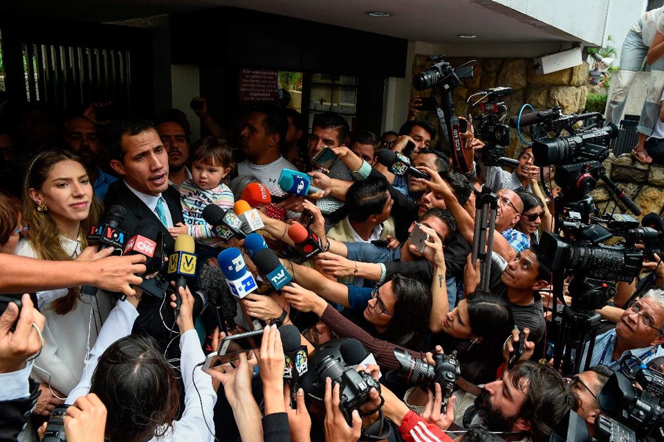 O presidente interino da Venezuela Juan Guaidó fala com a imprensa ao lado de sua esposa e com a filha no colo, em frente à sua casa em Santa Fé, Caracas, nesta quinta-feira |  FEDERICO PARRA / AFP