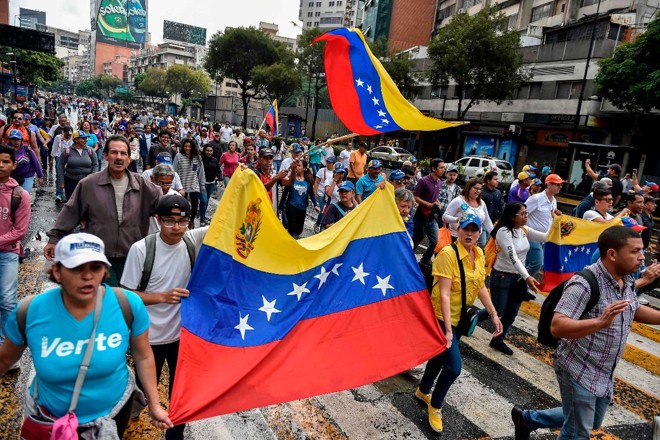 Na ruas de Caracas, milhares de pessoas protestam contra o ditador Nicolás Maduro | LUIS ROBAYO/AFP