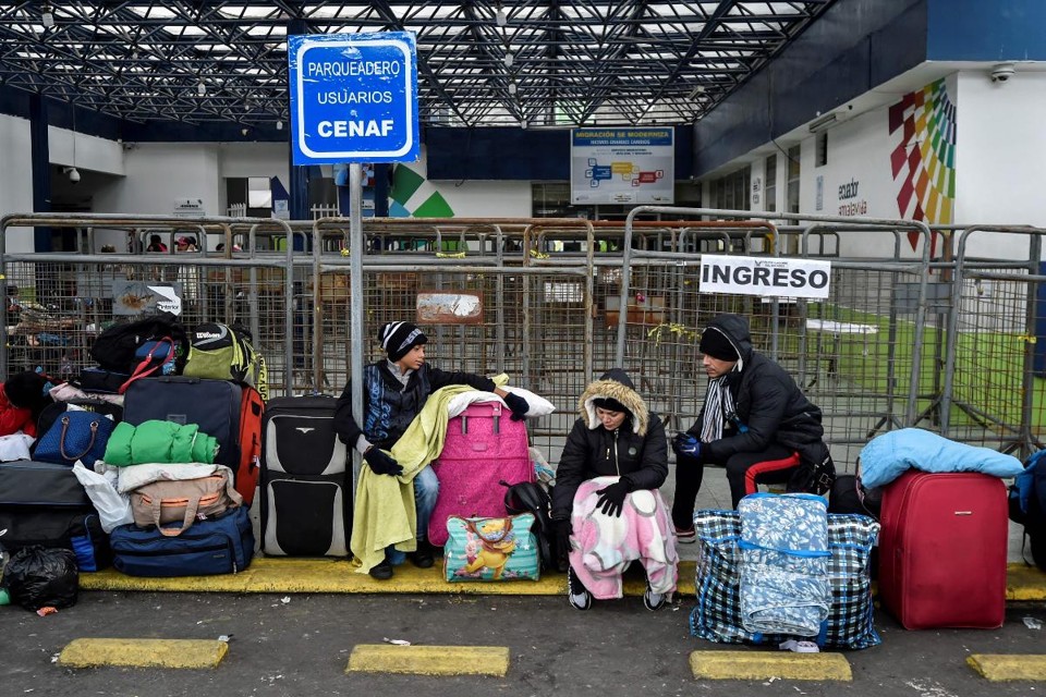 Migrantes venezuelanos esperam em frente ao escritório de migração do Equador, em Tulcan, antes de atravessar para Ipiales, na Colômbia, 20 de agosto | LUIS ROBAYO / AFP