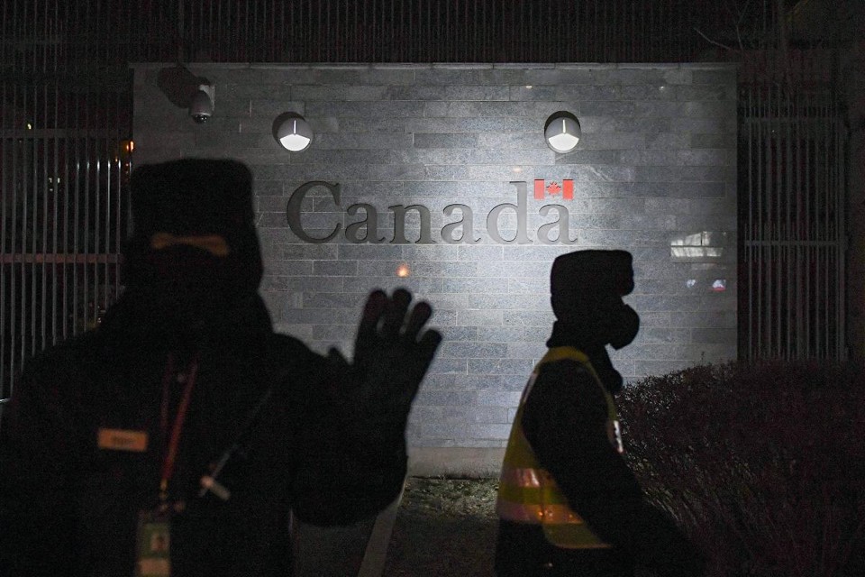 Guarda tenta impedir fotos da embaixada canadense em Pequim, em 14 de janeiro de 2019 | GREG BAKER/AFP