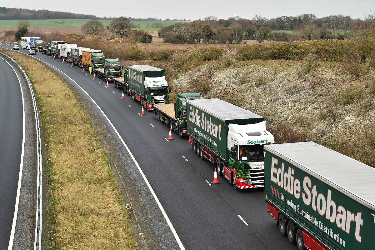 Caminhões são mantidos em fila a alguns quilômetros do porto de Dover, sul da Inglaterra, enquanto participam de um teste em preparação a possíveis engarrafamentos pós-Brexit | GLYN KIRK / AFP