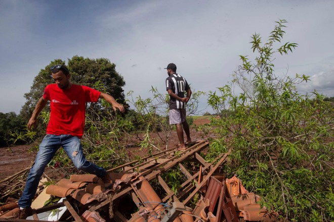 Moradores de Brumadinho observam a destruição causada pelo rompimento da barragem da Vale. | Mauro Pimentel/AFP